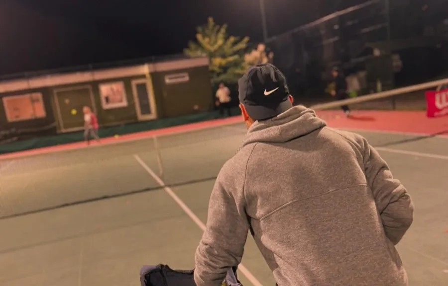 An adult coaching session on the floodlit hard courts at Blackheath Lawn Tennis Club